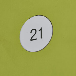 White circular sticker with the number 21 on a bright green surface